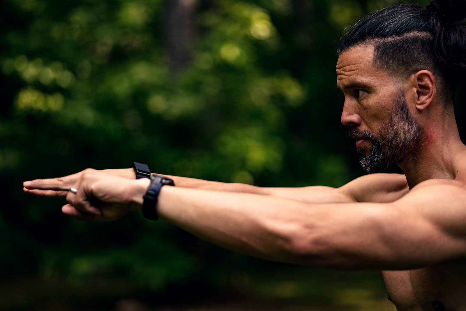 David Beaudry holding a Qigong posture, arm extended, in the forest